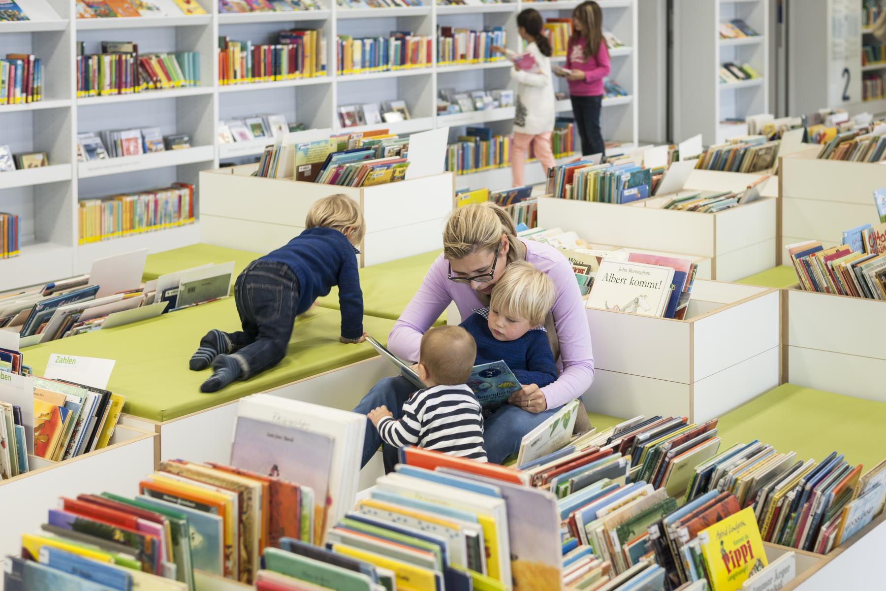 Vorlesesituation in der stadtbibliothek Stuttgart, bei der eineFrau ihren Kindern vorliest.